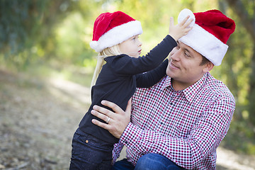 Image showing Father and Daughter Having Fun Wearing Santa Hats