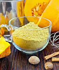 Image showing Flour pumpkin in glass cup with sieve and cinnamon on board