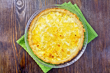 Image showing Pie with cheese and leek in glass pan on board