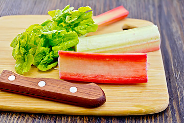 Image showing Rhubarb with knife and leaf on board