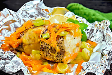 Image showing Pike with carrots and onions in foil on board