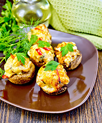 Image showing Champignons stuffed meat in brown plate on board