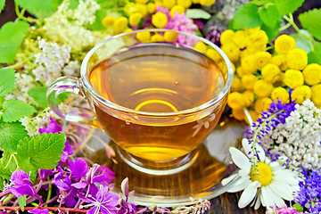 Image showing Tea from flowers in glass cup on dark board