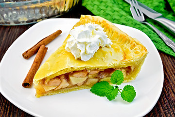 Image showing Pie apple with cream and mint in plate on board