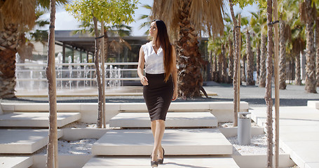 Image showing Elegant young woman walking through a park