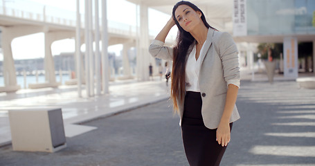 Image showing Stylish woman with long hair standing on a mobile