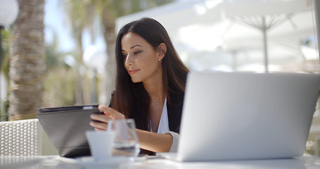 Image showing Businesswoman making a call at a restaurant