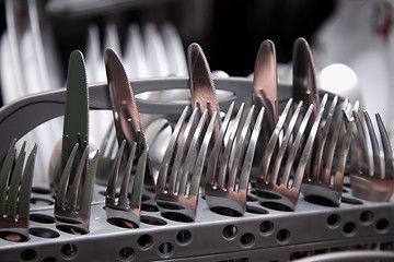 Image showing Open dishwasher with clean utensils