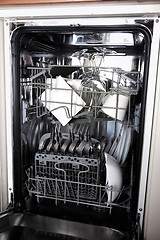 Image showing Open dishwasher with clean utensils