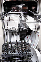 Image showing Open dishwasher with clean utensils