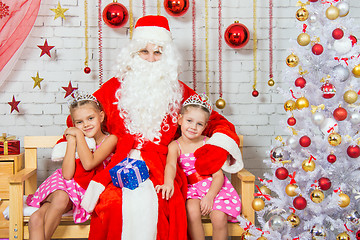 Image showing Santa Claus hugging two girls sisters