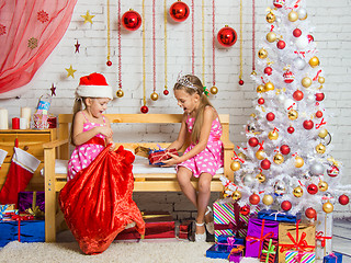 Image showing Two girls pulled out a bag of Christmas gifts Santa Claus