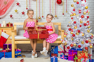 Image showing Happy girl who gave a great gift sitting on a bench in a Christmas setting