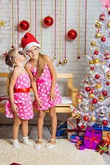 Image showing Girl whispers something to the other girl is in the Christmas stop