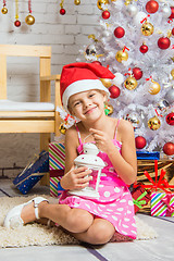 Image showing Happy girl holding a candle in his hand and sitting at the Christmas trees