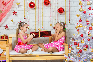 Image showing Sister gives girl a gift, girl peeking through closed eyes palms