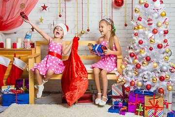 Image showing Two girls having fun and happy New Year gifts from Santa Claus bag
