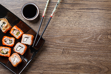 Image showing Sushi roll with chopsticks