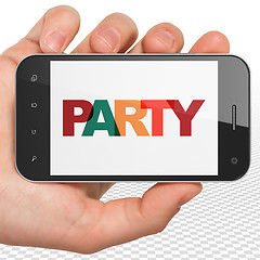 Image showing Entertainment, concept: Hand Holding Smartphone with Party on  display