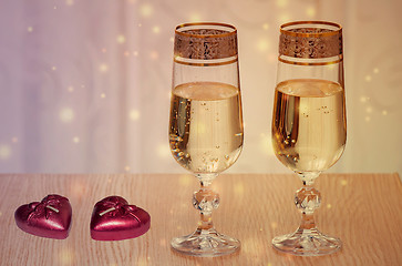 Image showing Two wine glasses filled with champagne, and candles.