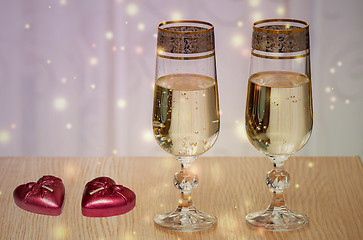 Image showing Two wine glasses filled with champagne, and candles.