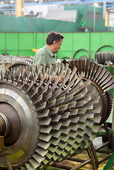 Image showing Mechanic works with parts of aviation engine