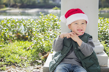 Image showing Cute Mixed Race Boy With Santa Hat and Candy Cane