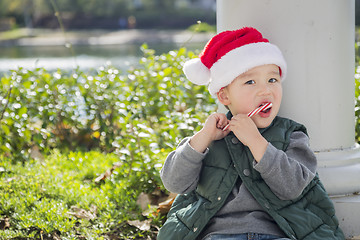 Image showing Cute Mixed Race Boy With Santa Hat and Candy Cane