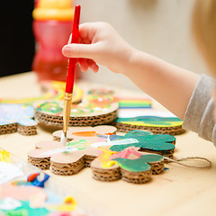 Image showing Little female baby painting with colorful paints