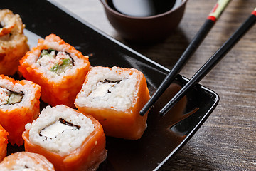 Image showing Sushi roll with chopsticks