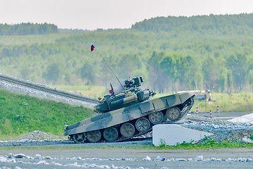 Image showing Tank T-80 overcomes a high concrete obstacle