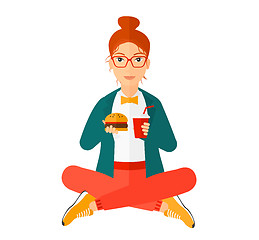 Image showing Woman eating hamburger. 