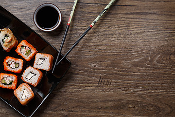 Image showing Sushi roll with chopsticks