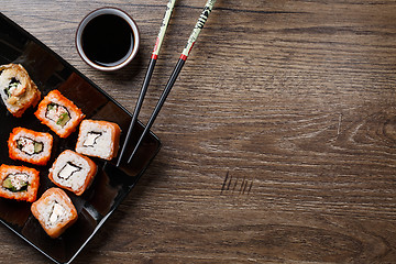 Image showing Sushi roll with chopsticks