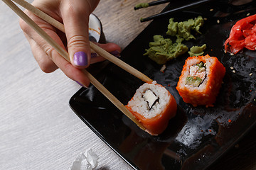 Image showing Sushi. Hand with chopsticks