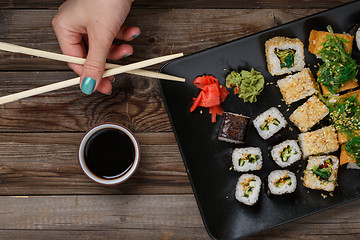 Image showing Sushi. Hand with chopsticks