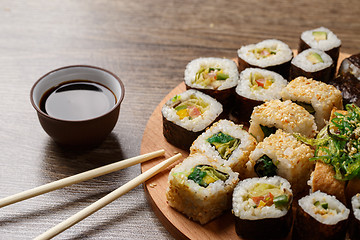 Image showing Sushi set at round wooden plate 