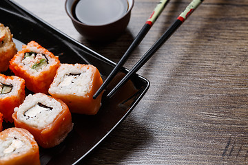 Image showing Sushi roll with chopsticks