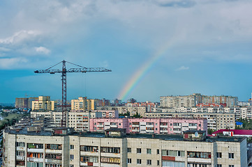 Image showing Residential district with cranes and rainbow