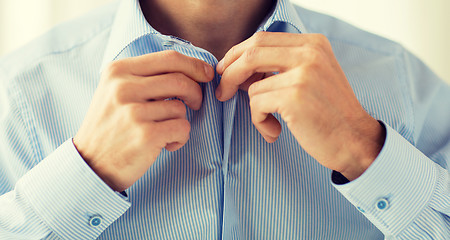 Image showing close up of man in shirt dressing 