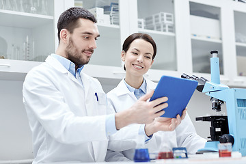 Image showing scientists with tablet pc and microscope in lab