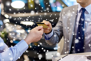 Image showing customer giving credit card to car dealer in salon