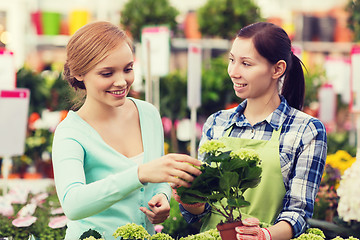 Image showing happy women choosing flowers in greenhouse