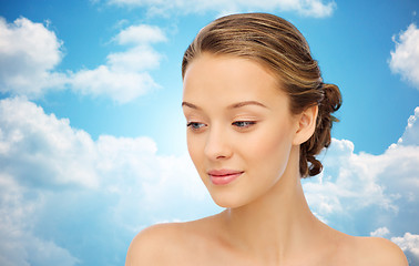 Image showing smiling young woman face over blue sky