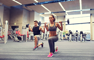 Image showing young man and woman training with barbell in gym