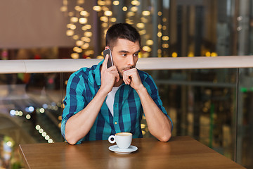 Image showing man with smartphone and coffee at restaurant