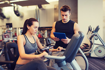 Image showing woman with trainer on exercise bike in gym