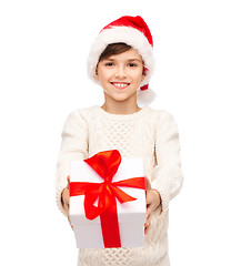 Image showing smiling happy boy in santa hat with gift box