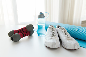 Image showing close up of bottle, dumbbells, sneakers and mat