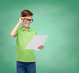 Image showing happy boy in eyeglasses holding school test result